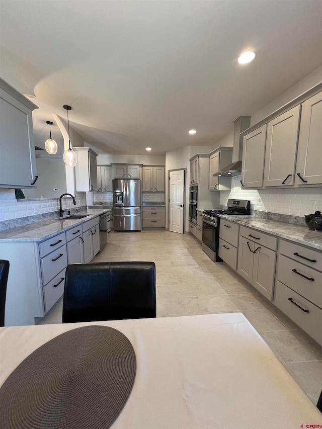 kitchen with appliances with stainless steel finishes, sink, gray cabinets, and pendant lighting