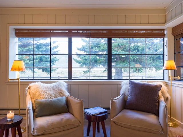 sitting room featuring a baseboard radiator, carpet, and wood walls