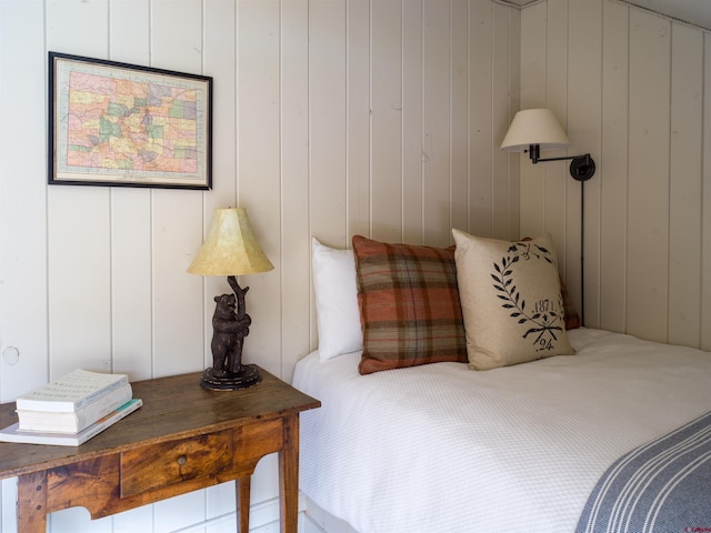 bedroom featuring wooden walls