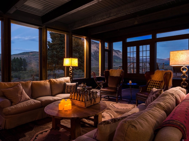 living room featuring a mountain view, wooden ceiling, and beam ceiling