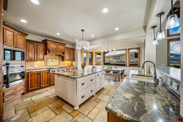 kitchen featuring decorative backsplash, stainless steel appliances, pendant lighting, a chandelier, and white cabinetry