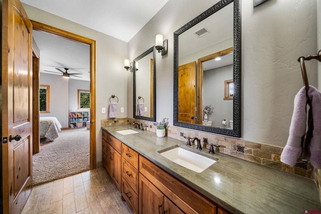 bathroom with toilet, wood-type flooring, ceiling fan, vanity, and tasteful backsplash