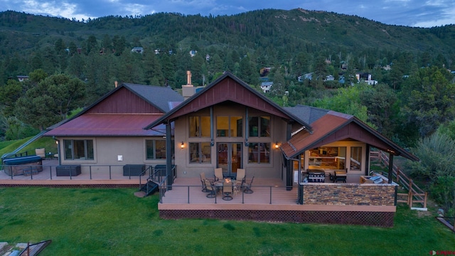 back of property featuring outdoor lounge area, a lawn, and a deck with mountain view