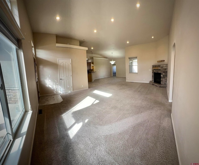 unfurnished living room with carpet and a stone fireplace