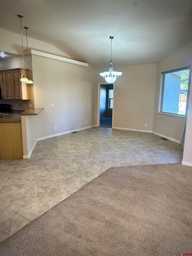 unfurnished living room featuring light colored carpet, vaulted ceiling, and a notable chandelier