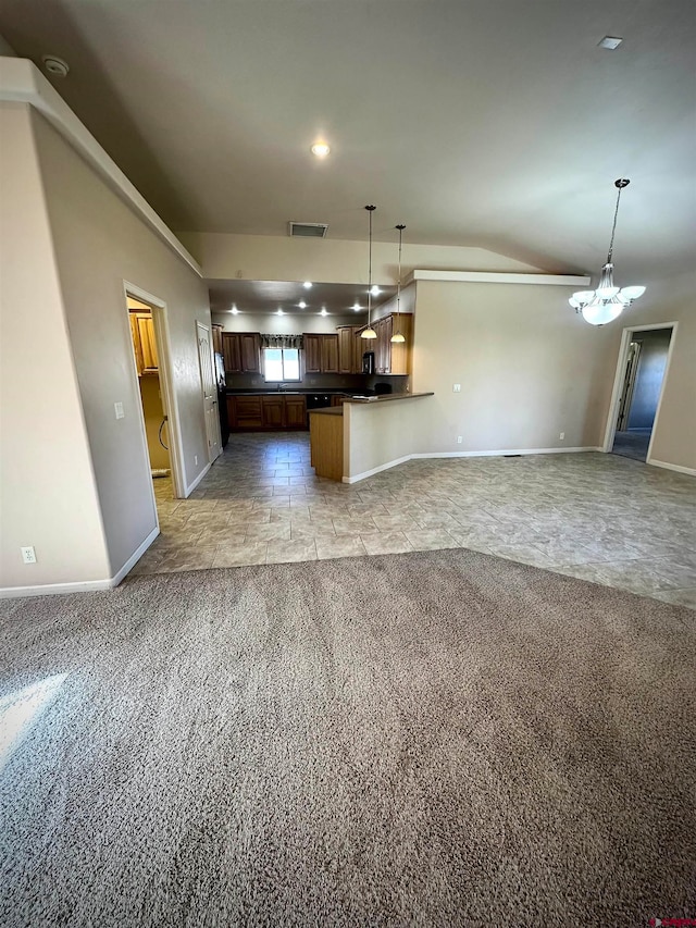 kitchen featuring decorative light fixtures, kitchen peninsula, light carpet, and an inviting chandelier