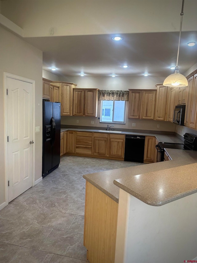 kitchen featuring black appliances, decorative light fixtures, kitchen peninsula, and sink