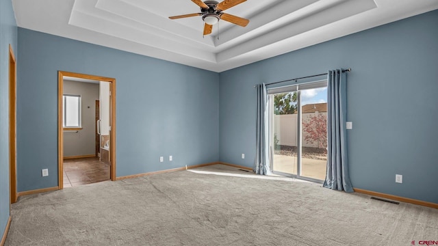 empty room featuring carpet and a tray ceiling