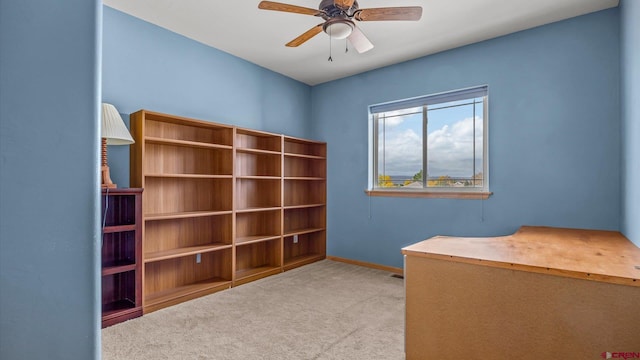 unfurnished office with ceiling fan and light colored carpet