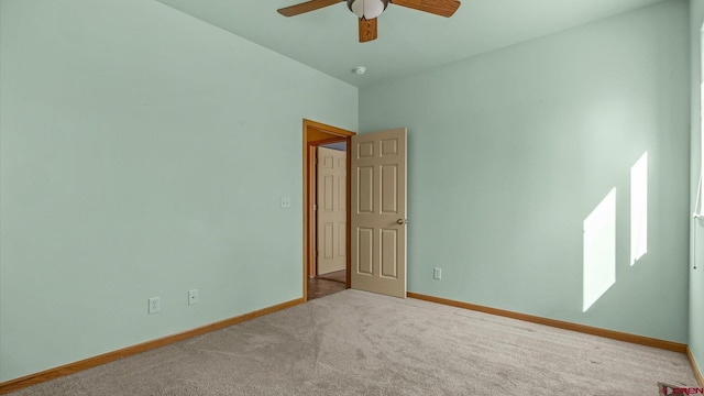 spare room featuring light carpet and ceiling fan