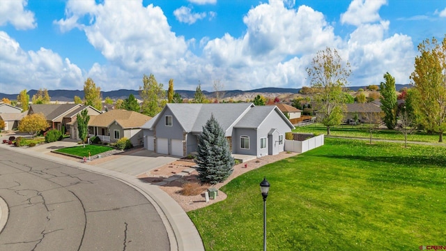 view of front of property with a front yard, a garage, and a mountain view