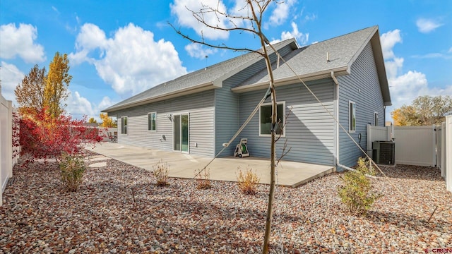 rear view of property with central air condition unit and a patio area