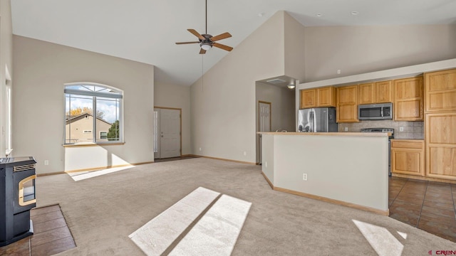 kitchen with light carpet, high vaulted ceiling, appliances with stainless steel finishes, and tasteful backsplash