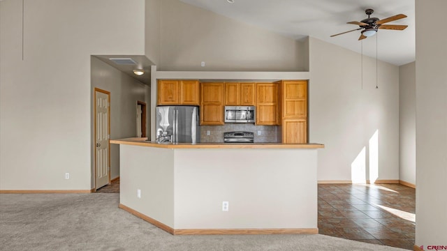 kitchen featuring backsplash, ceiling fan, stainless steel appliances, high vaulted ceiling, and light colored carpet