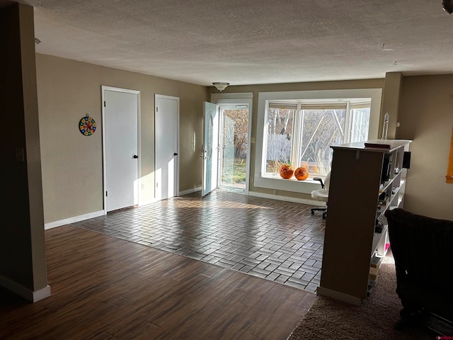 spare room with a textured ceiling and dark wood-type flooring