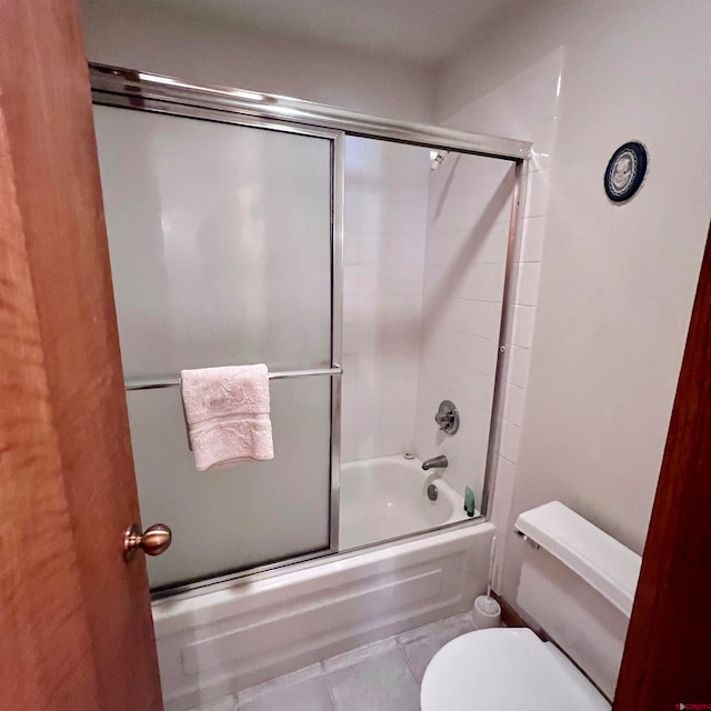 bathroom featuring tile patterned floors, bath / shower combo with glass door, and toilet