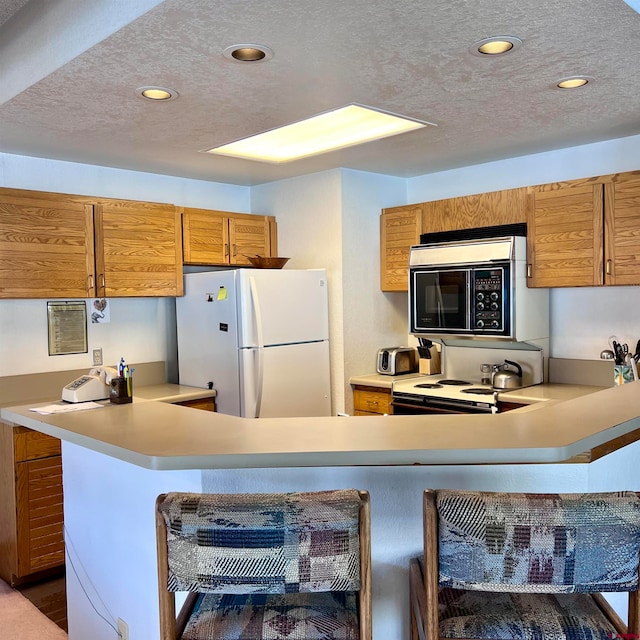 kitchen with kitchen peninsula, a textured ceiling, range with electric stovetop, and white refrigerator