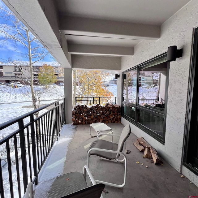 view of snow covered back of property