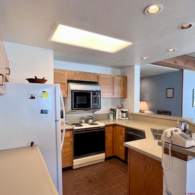 kitchen featuring kitchen peninsula, a textured ceiling, and white appliances