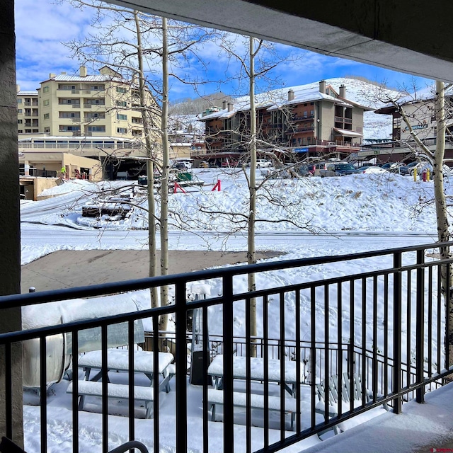 view of snow covered back of property