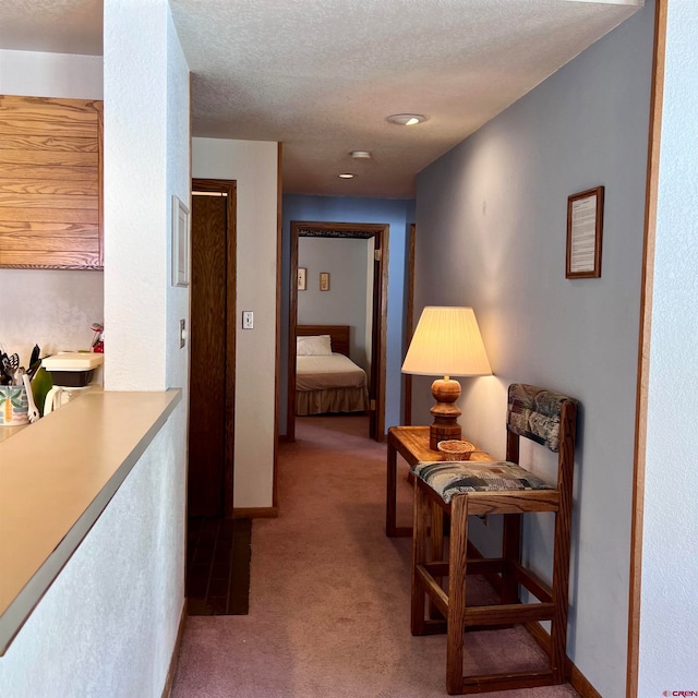 hallway with carpet and a textured ceiling