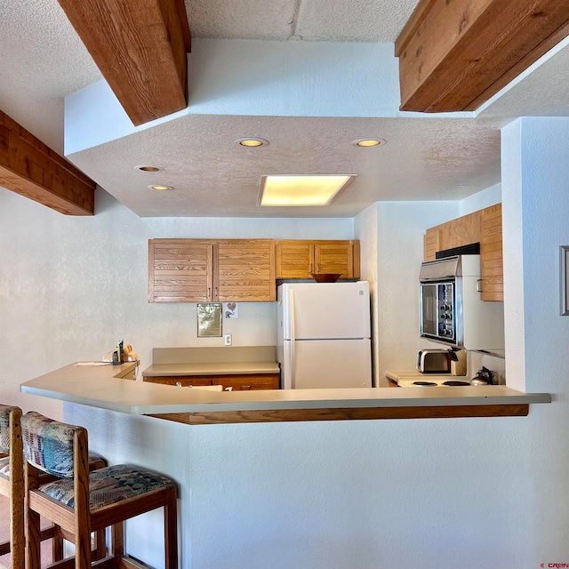 kitchen featuring fridge, a textured ceiling, and white refrigerator