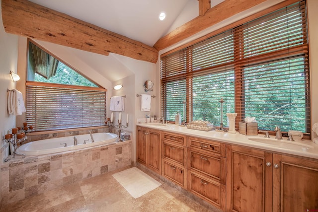 bathroom featuring vanity, tiled tub, and vaulted ceiling