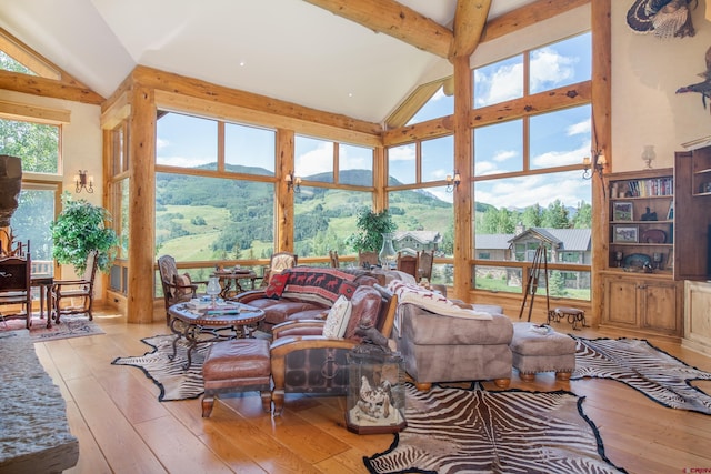 living room with beam ceiling, a mountain view, high vaulted ceiling, and light hardwood / wood-style floors