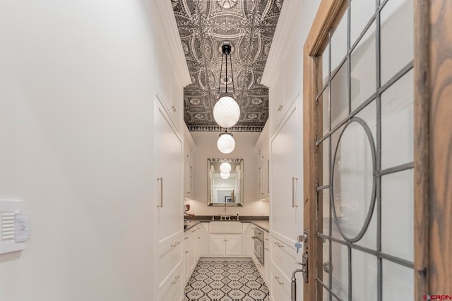 interior space featuring ornamental molding, sink, and a high ceiling