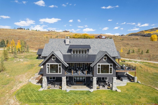 rear view of property featuring a patio area and a lawn