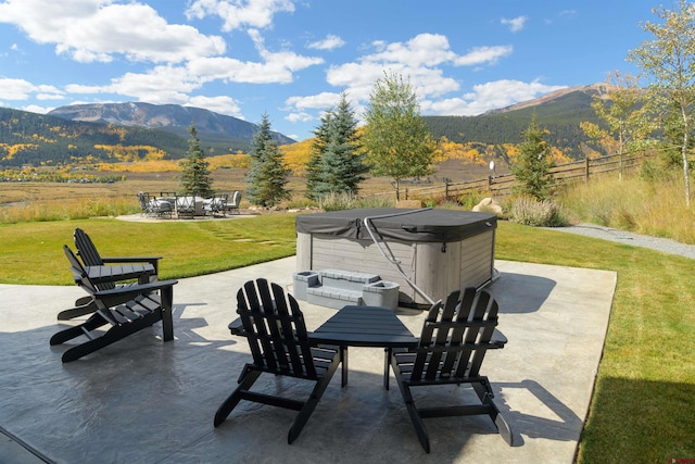 view of patio / terrace with a hot tub and a mountain view