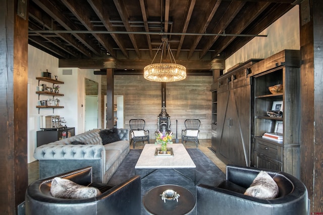 living room with a notable chandelier, wood walls, and a barn door