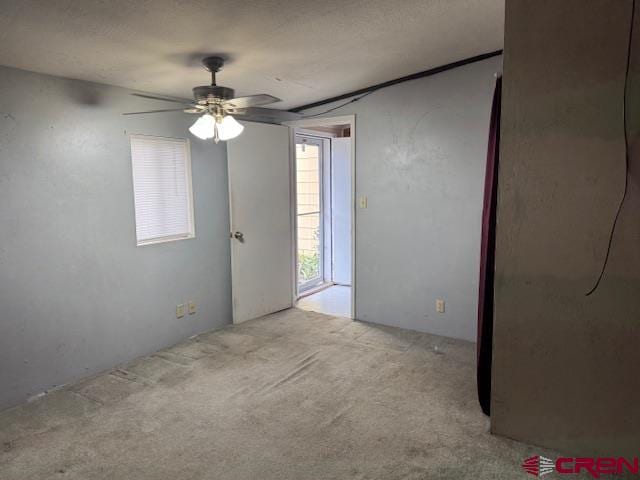 empty room featuring ceiling fan and light colored carpet