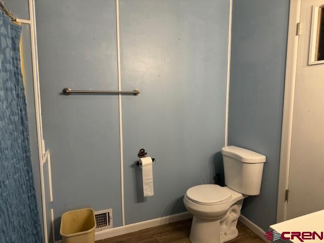 bathroom featuring hardwood / wood-style flooring and toilet