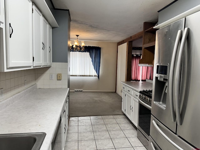 kitchen featuring a chandelier, appliances with stainless steel finishes, white cabinetry, and hanging light fixtures