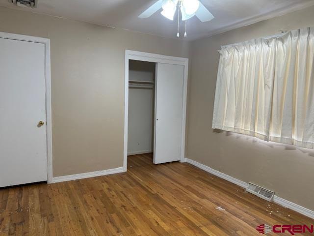 unfurnished bedroom featuring hardwood / wood-style flooring and ceiling fan