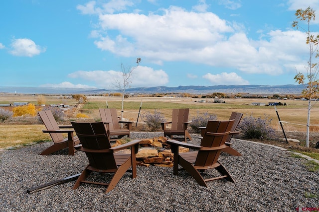 view of patio / terrace featuring a mountain view, a rural view, and a fire pit