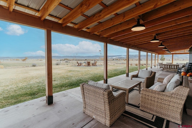 view of patio / terrace with ceiling fan, a rural view, and an outdoor hangout area