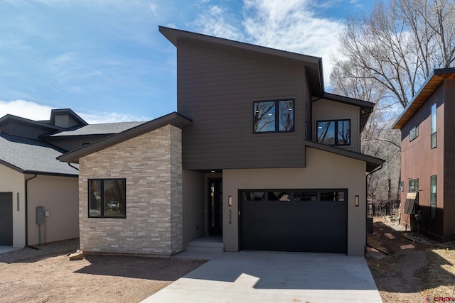 538 Hermosa Meadows Rd, Durango, CO 81301 - contemporary home featuring concrete driveway, an attached garage, stone siding, and stucco siding