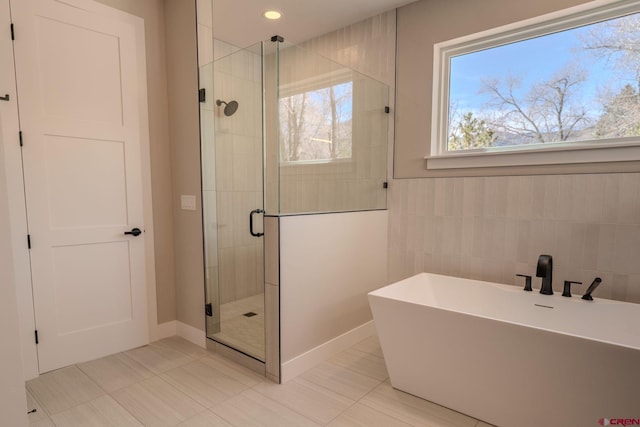 538 Hermosa Meadows Rd, Durango, CO 81301 - full bath featuring a stall shower, a freestanding bath, tile walls, and baseboards