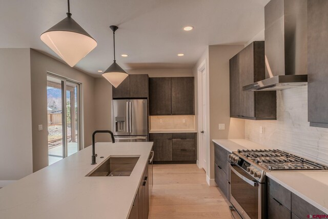 538 Hermosa Meadows Rd, Durango, CO 81301 - kitchen with appliances with stainless steel finishes, a sink, wall chimney exhaust hood, dark brown cabinetry, and light countertops
