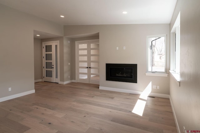 538 Hermosa Meadows Rd, Durango, CO 81301 - unfurnished living room with light wood-style flooring, baseboards, a glass covered fireplace, and recessed lighting