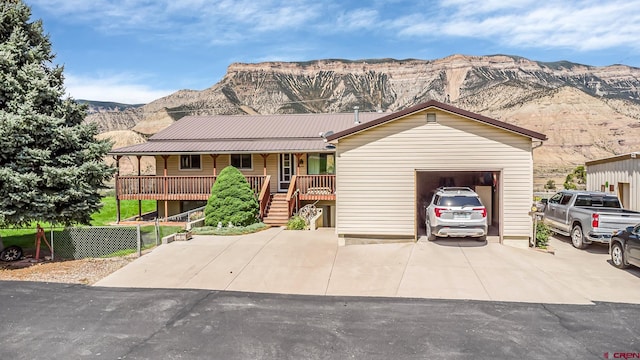 ranch-style home featuring a garage, a mountain view, and a porch