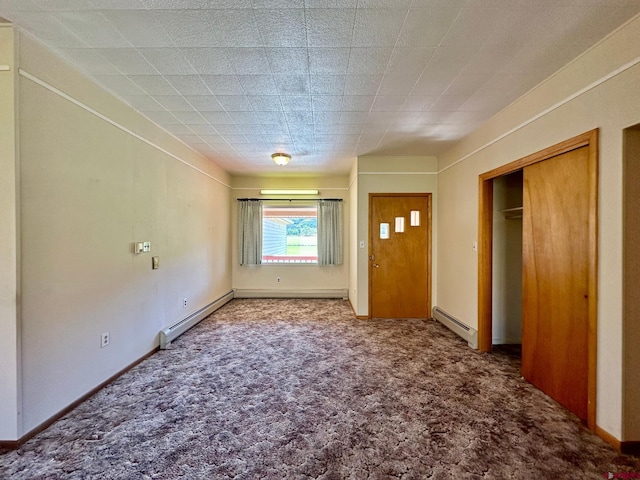 unfurnished bedroom with a baseboard heating unit and carpet floors