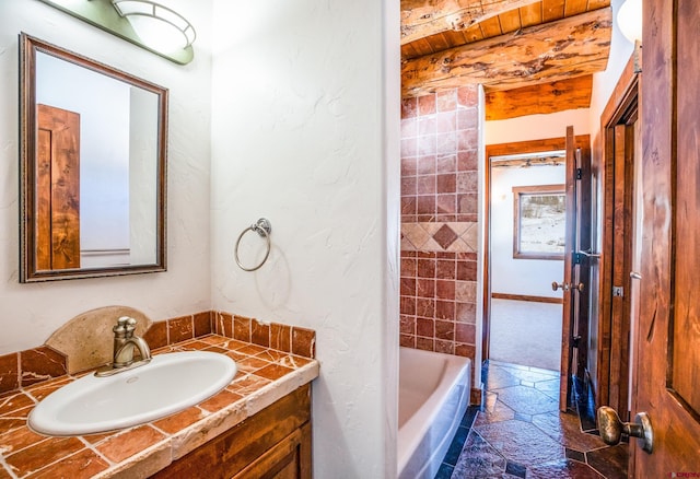 bathroom featuring beamed ceiling, vanity, wood ceiling, and a bath