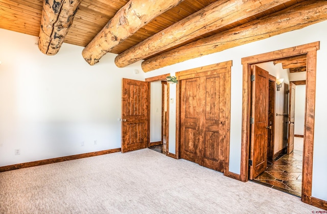 unfurnished bedroom featuring wood ceiling, beam ceiling, and dark carpet