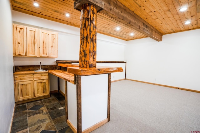 kitchen with wood ceiling, kitchen peninsula, a breakfast bar, dark carpet, and sink