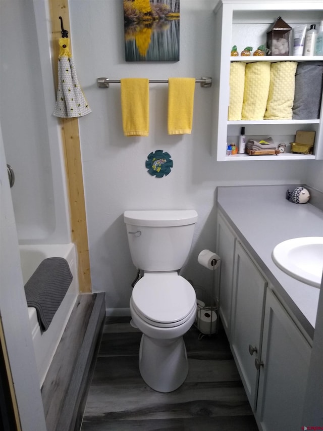 bathroom featuring walk in shower, wood-type flooring, vanity, and toilet