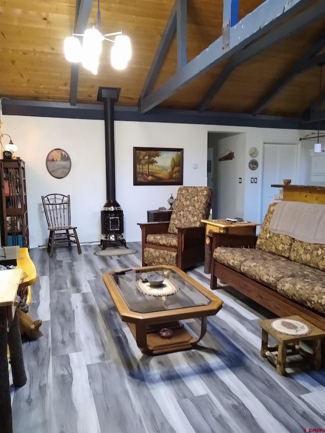 living room featuring a wood stove, hardwood / wood-style floors, vaulted ceiling with beams, and wood ceiling