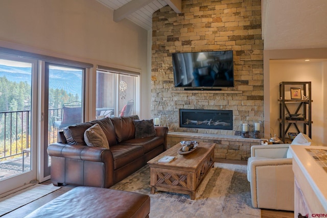 living room featuring a fireplace, beam ceiling, light hardwood / wood-style flooring, and high vaulted ceiling